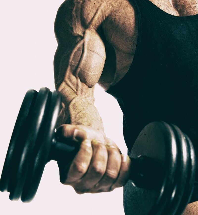 man lifting black dumbbell