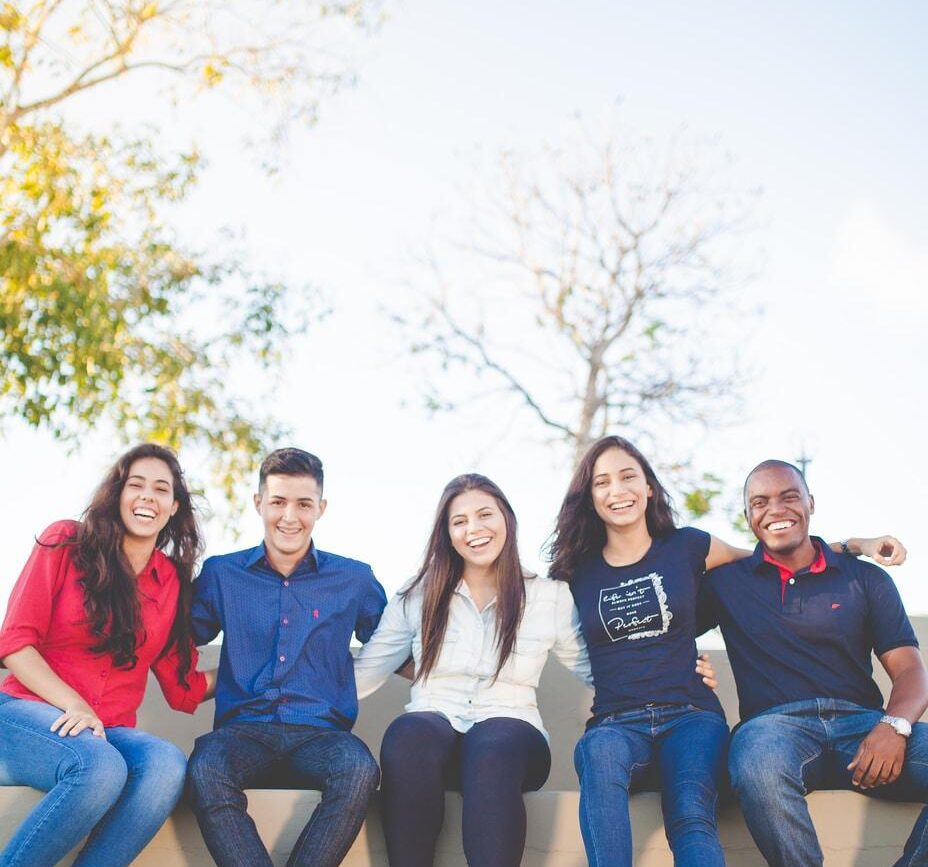 group of people sitting on bench near trees duting daytime