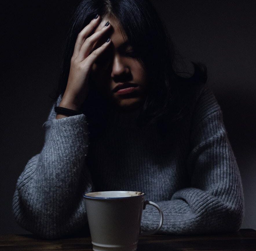 woman in gray sweater seating on chair