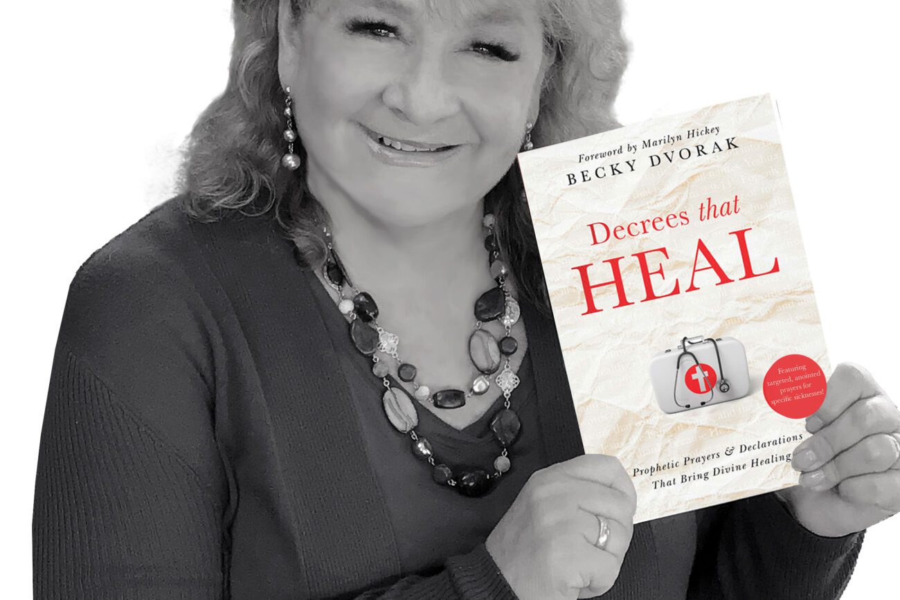Becky Dvorak holding Decrees That HEAL book