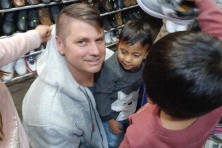 Aaron Helping the Kids with Their New Shoes.